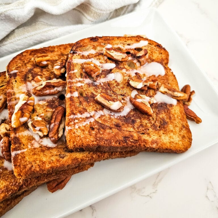 "Cinnamon Baked French Toast topped with powdered sugar and fresh berries in a baking dish"