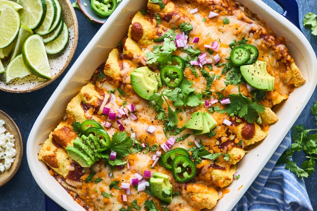 Vegetarian Enchiladas topped with melted cheese, fresh cilantro, and a side of guacamole