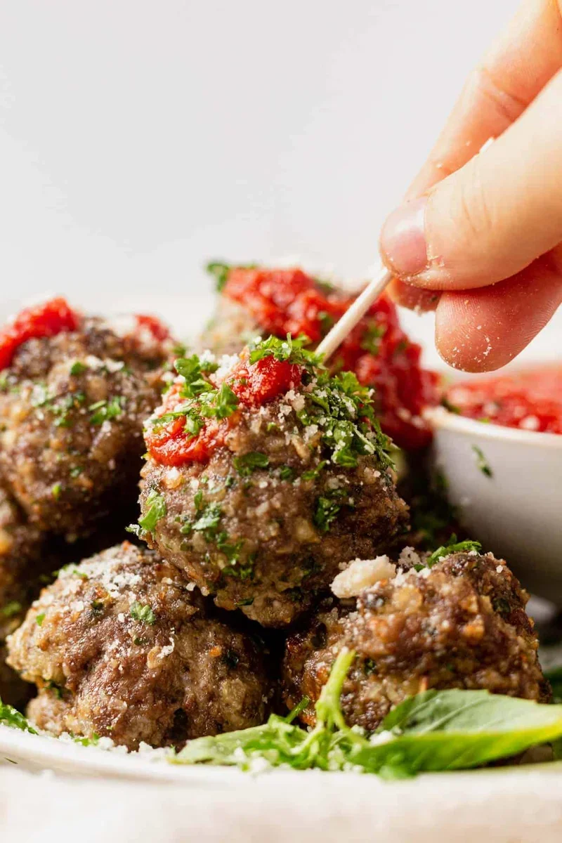 air fryer meatballs served over spaghetti with marinara sauce and Parmesan cheese
