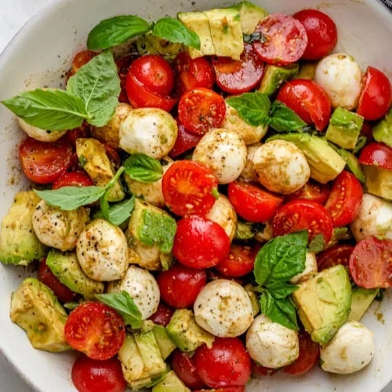 finished avocado caprese salad with mozzarella, tomatoes, and basil drizzle