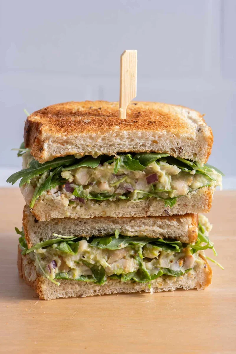 creamy avocado and white bean spread on whole grain bread with fresh greens