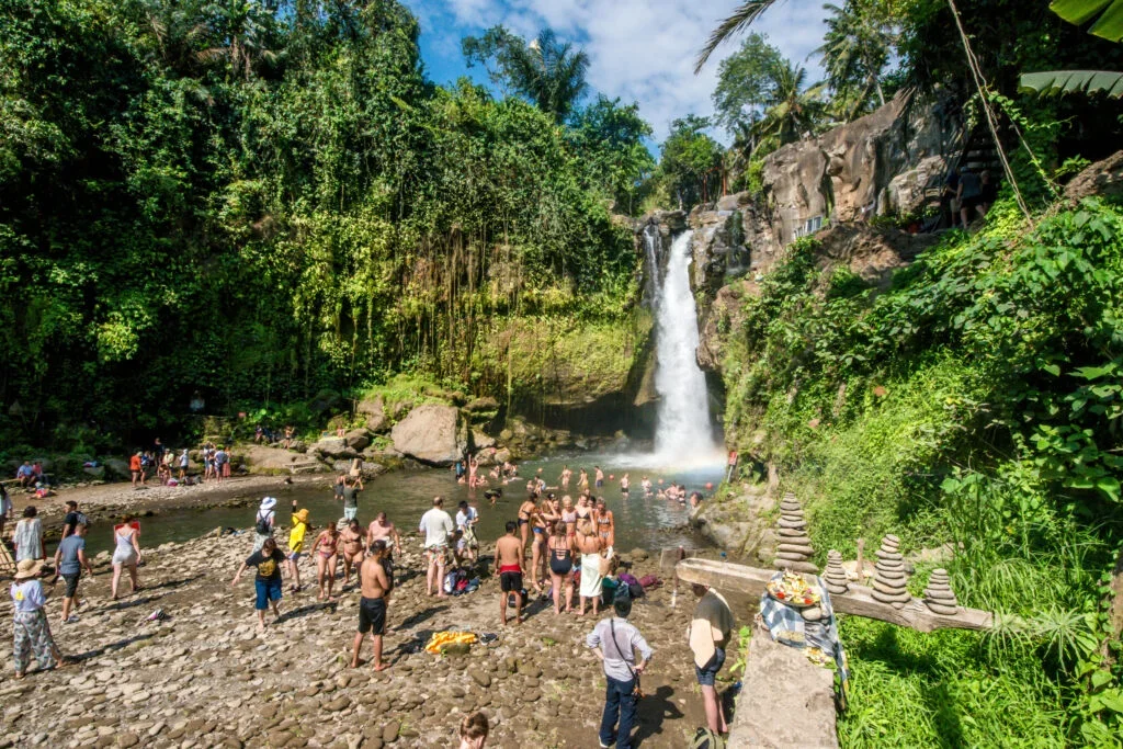 crowded Balinese temple with tourists surrounding sacred water pools