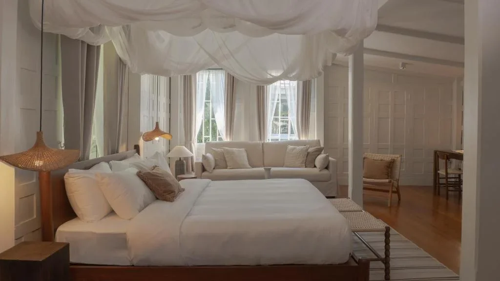 spacious hotel room with earthy tones and wooden furniture at Busaba Ayutthaya