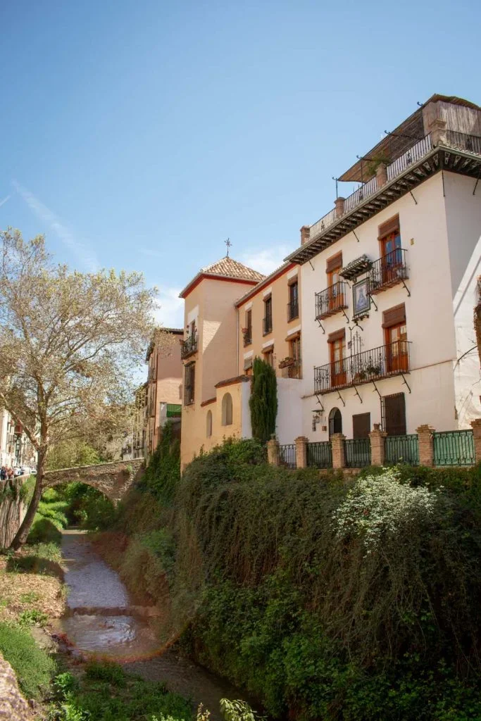 Carrera del Darro cobblestone street alongside Darro River with Alhambra views