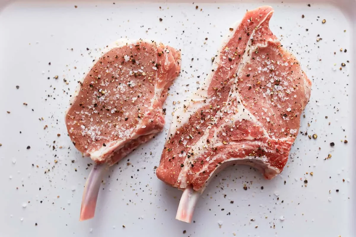 Cast Iron Pork Chops Recipe - The Cookie Rookie® 5 bone-in pork chops seasoned with salt and pepper ready for cooking