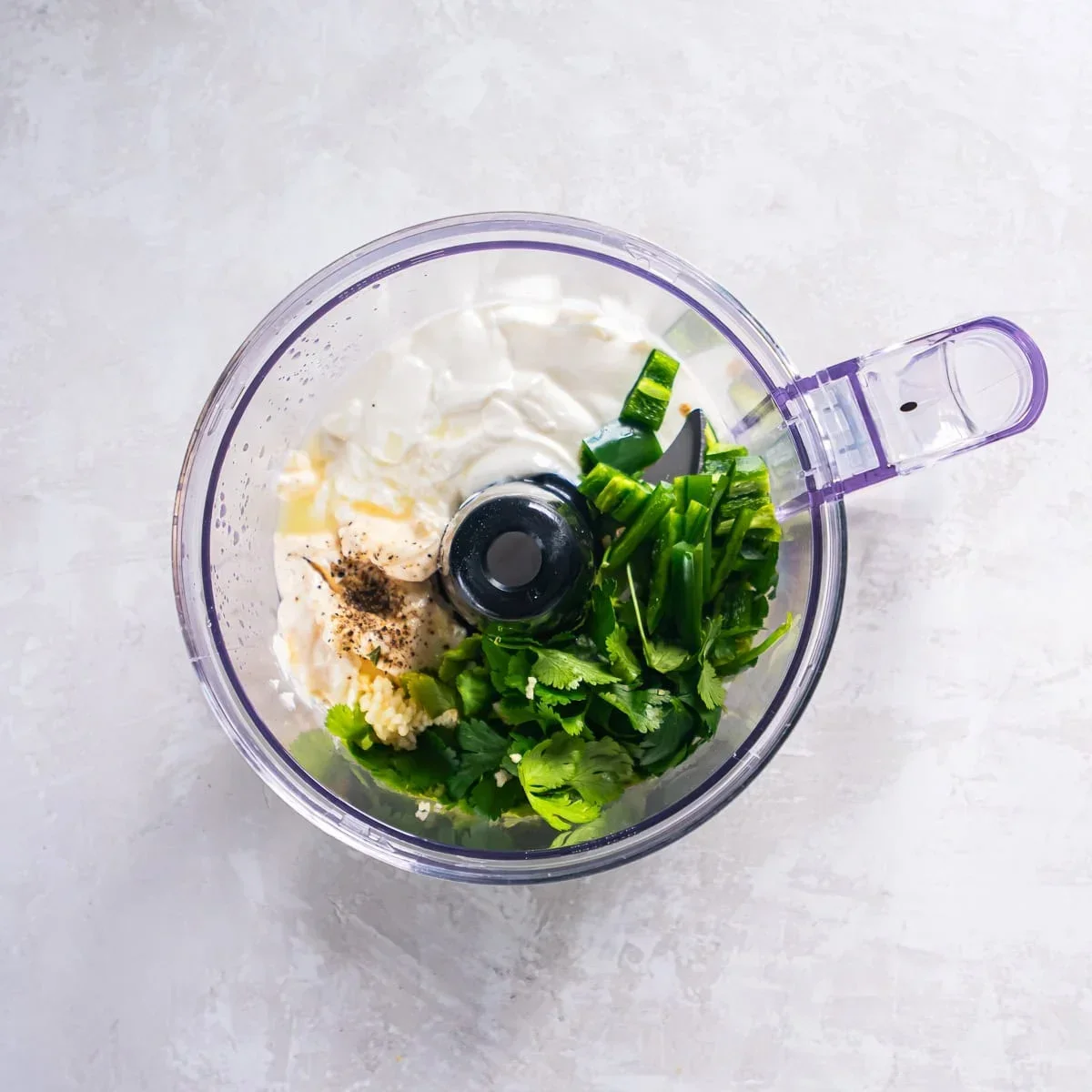 Fresh cilantro, lime juice, sour cream, and mayonnaise ready to blend into sauce