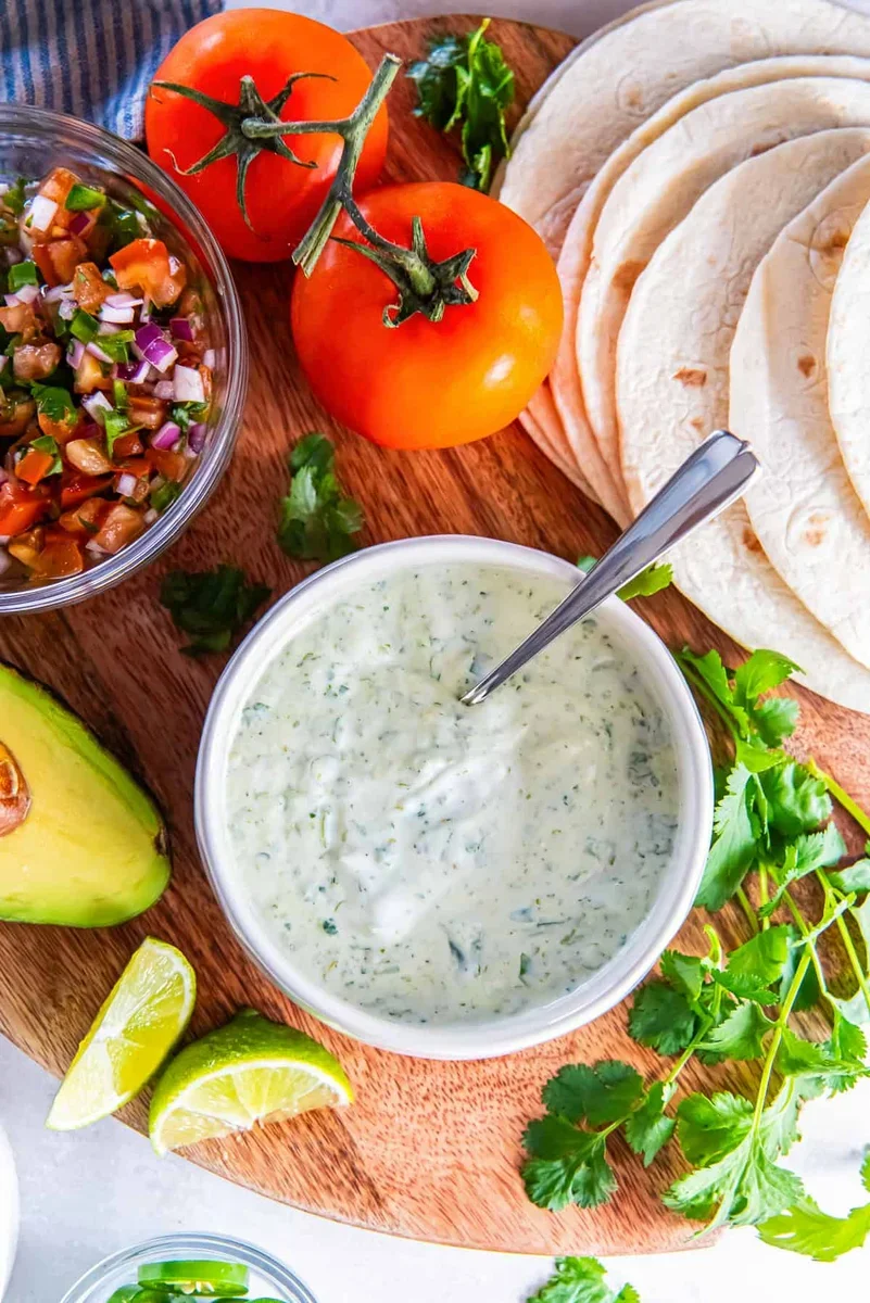 glass jar of fresh cilantro lime sauce with lime wedge
