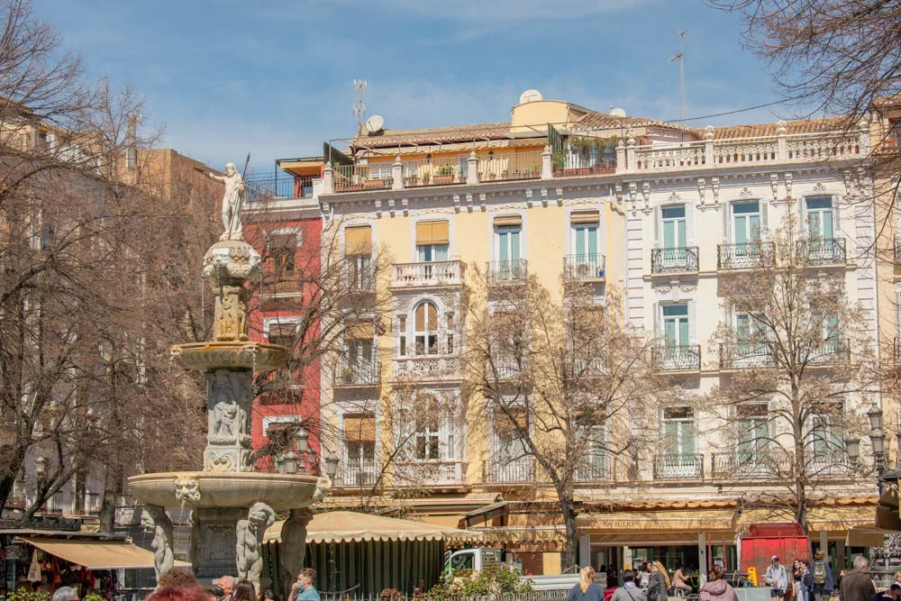 Outdoor cafe seating at Plaza de Bib-Rambla in Granada with historic architecture
