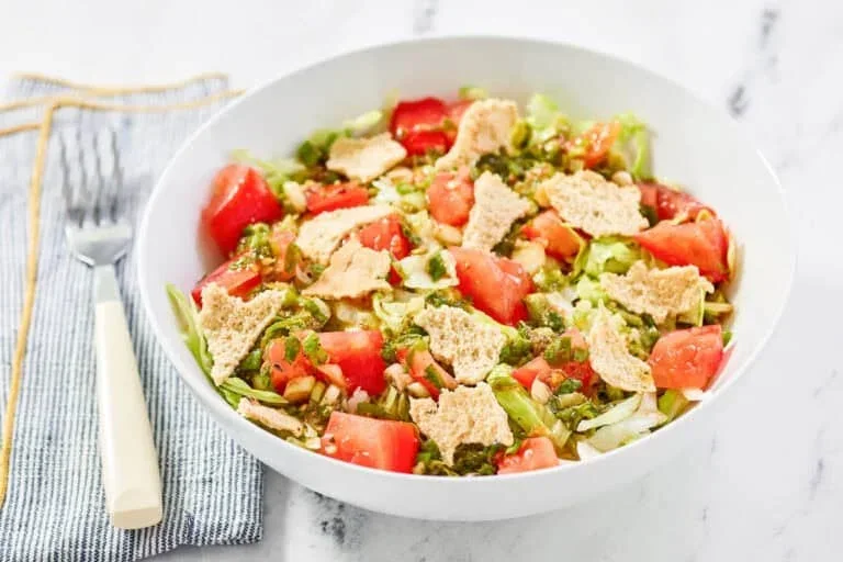 17 Spring Brunch Salads That Feel Fresh 14 green jacket salad in a white bowl with crisp greens, tomatoes, cucumbers and parmesan