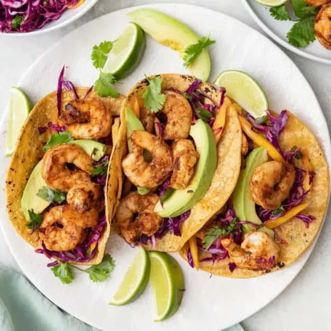 fresh grilled shrimp tacos with red cabbage slaw and lime wedges