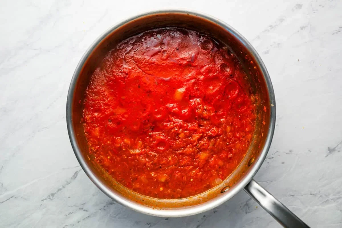 Homemade Spaghetti Sauce Recipe - The Cookie Rookie® 3 adding crushed tomatoes and seasonings to spaghetti sauce pot