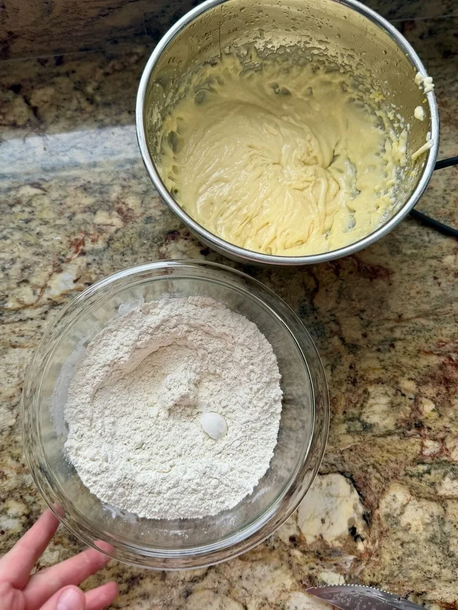 Creamy lemon crinkle cookie dough being mixed in a glass bowl