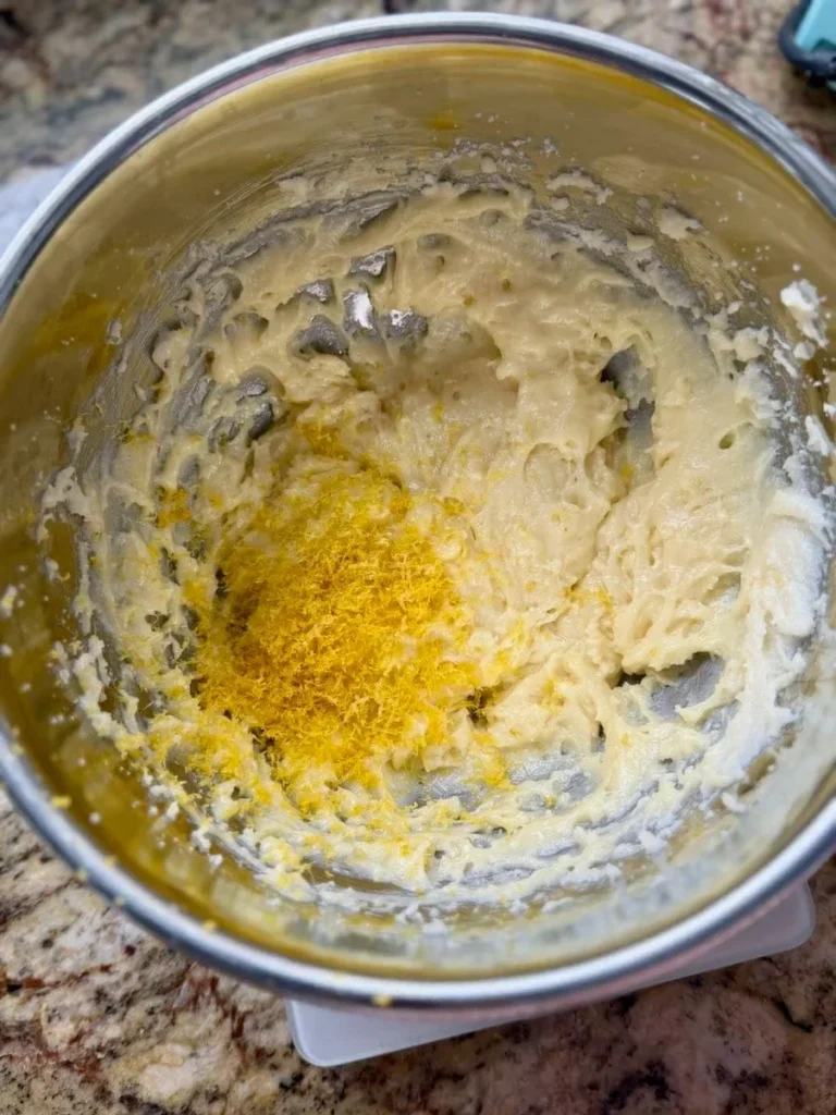 lemon crinkle cookie dough rolled in powdered sugar ready for baking