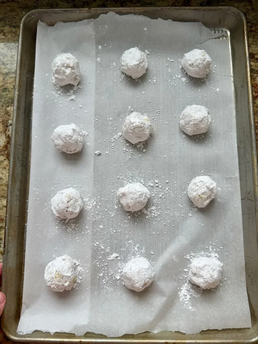 lemon crinkle cookie dough rolled in powdered sugar ready for baking
