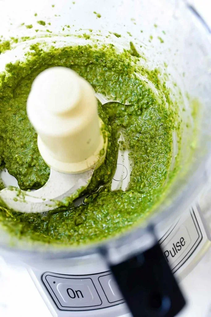 THE BEST Fresh Basil and Pine Nut Pesto - foodiecrush 4 creamy green basil pesto sauce in food processor with fresh ingredients