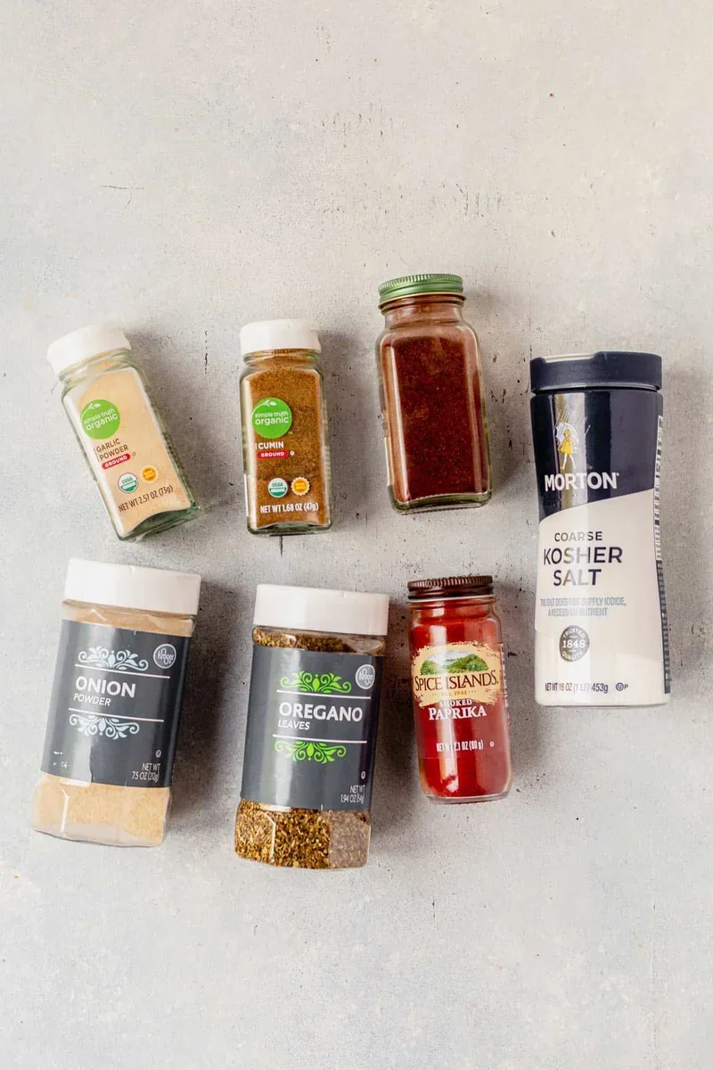 combining spices for authentic carnitas seasoning in mixing bowl