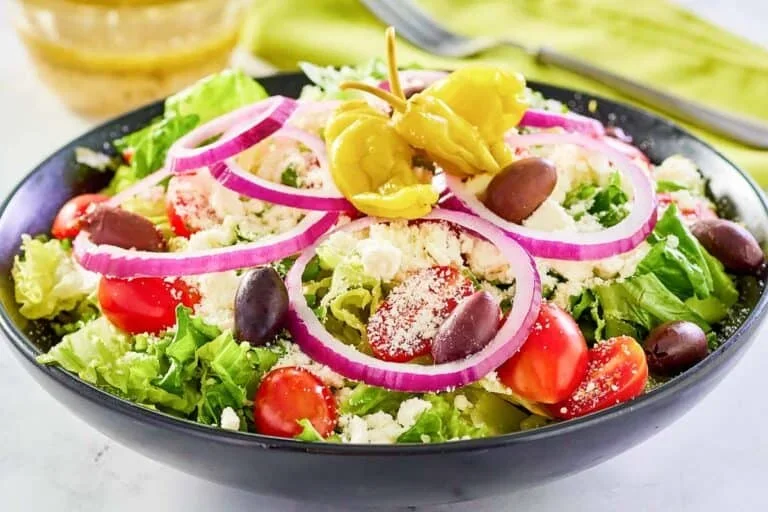 17 Spring Brunch Salads That Feel Fresh 3 Panera Greek salad with crisp vegetables, feta cheese, and tangy vinaigrette in a white bowl