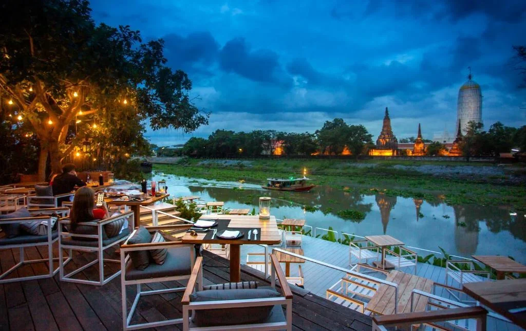 Sala Ayutthaya luxury hotel with pool and view of Wat Phutthaisawan at sunset