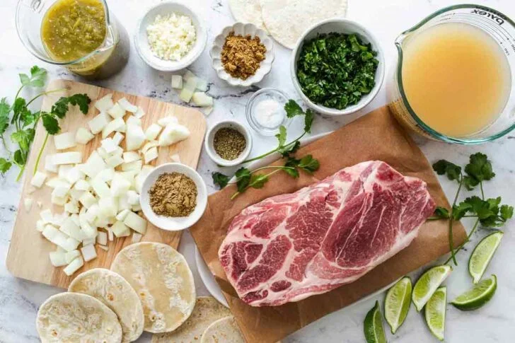 ingredients for salsa verde shredded pork tacos including pork, tortillas, and toppings