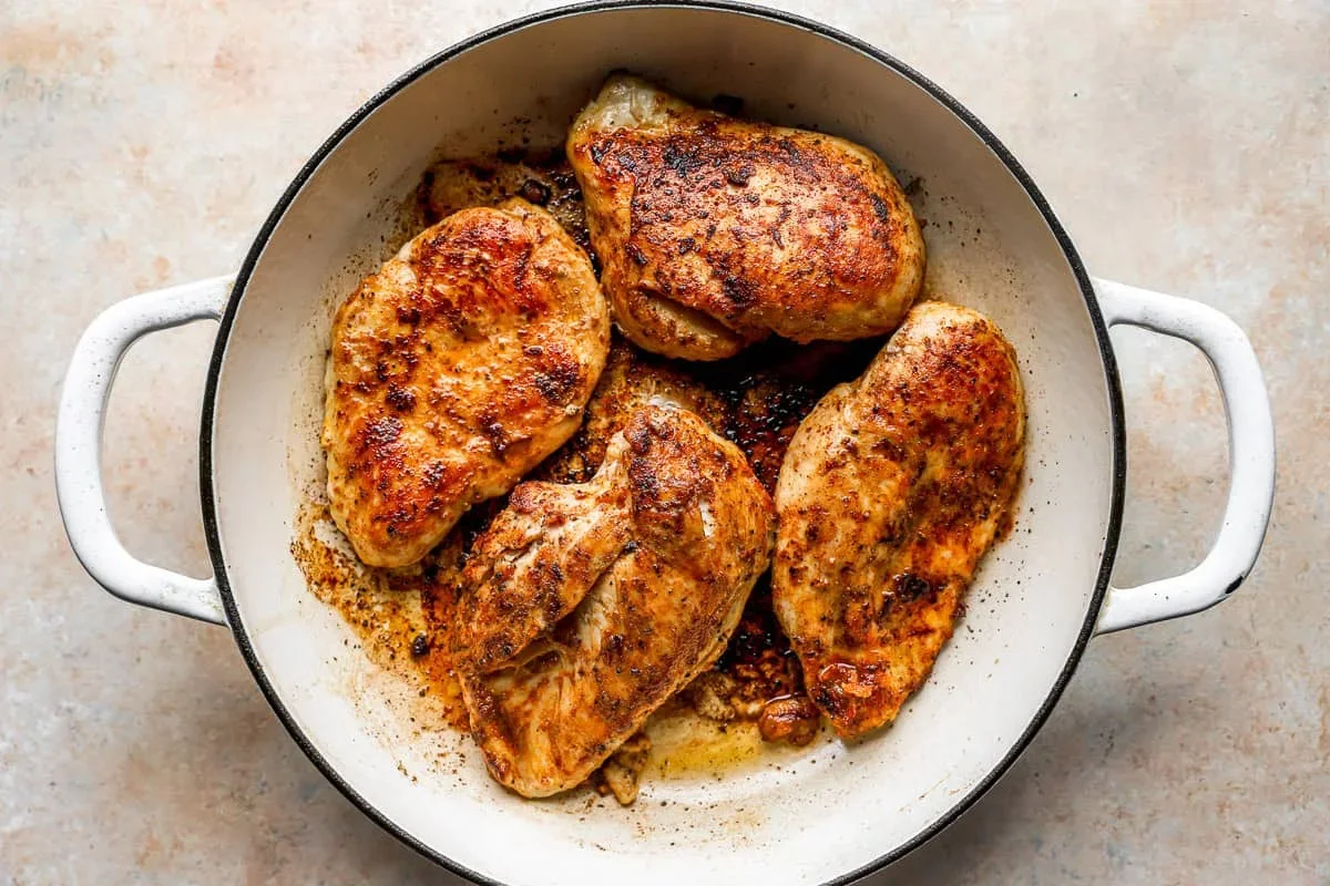 golden brown seared chicken breasts in cast iron skillet