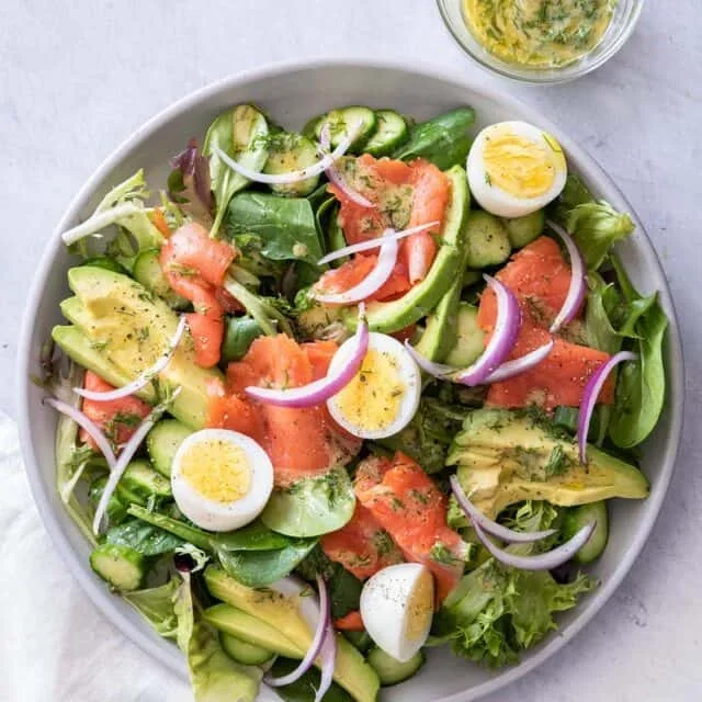 fresh smoked salmon salad with avocado and lemon dressing on a plate