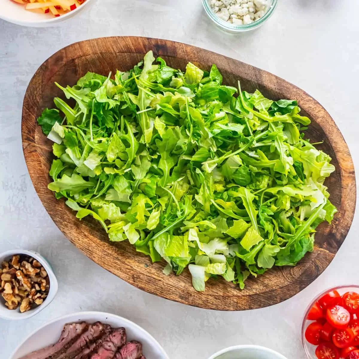 fresh romaine lettuce and arugula greens in a large salad bowl