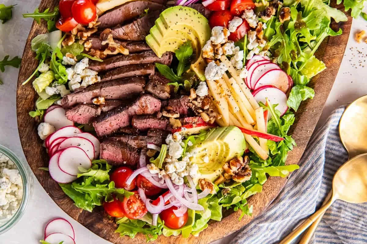 thinly sliced top sirloin steak for salad arranged on a cutting board