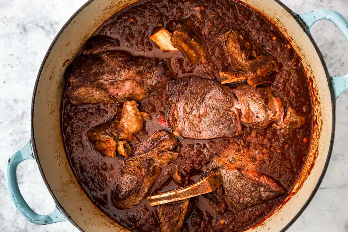 using an immersion blender to puree the birria sauce until smooth