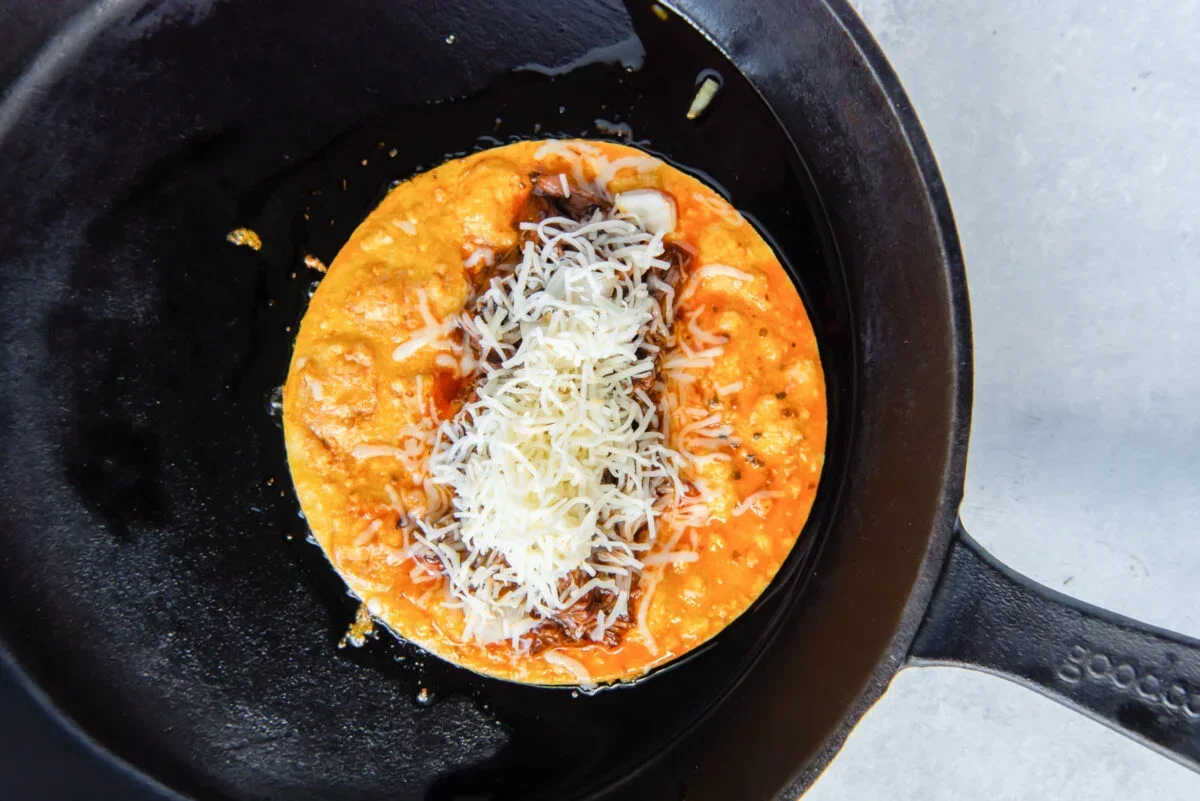 Homemade Birria Tacos Recipe with Crispy Dipping Sauce 9 shredding cooked beef for birria tacos with two forks in a pot
