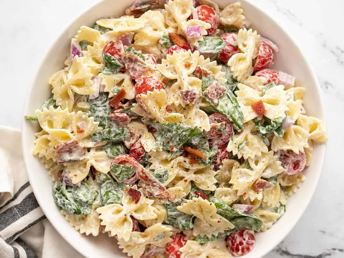 blt pasta salad served on a large platter with grilled chicken and corn