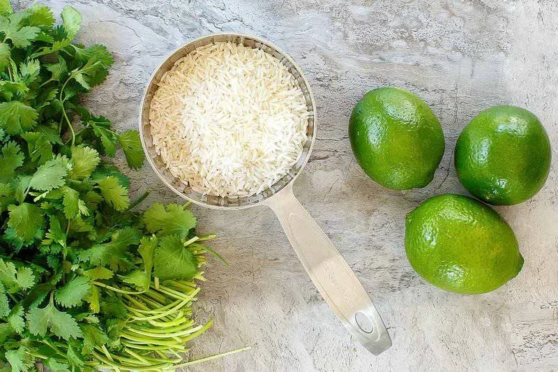 fluffy cilantro lime rice with fresh cilantro and lime wedges