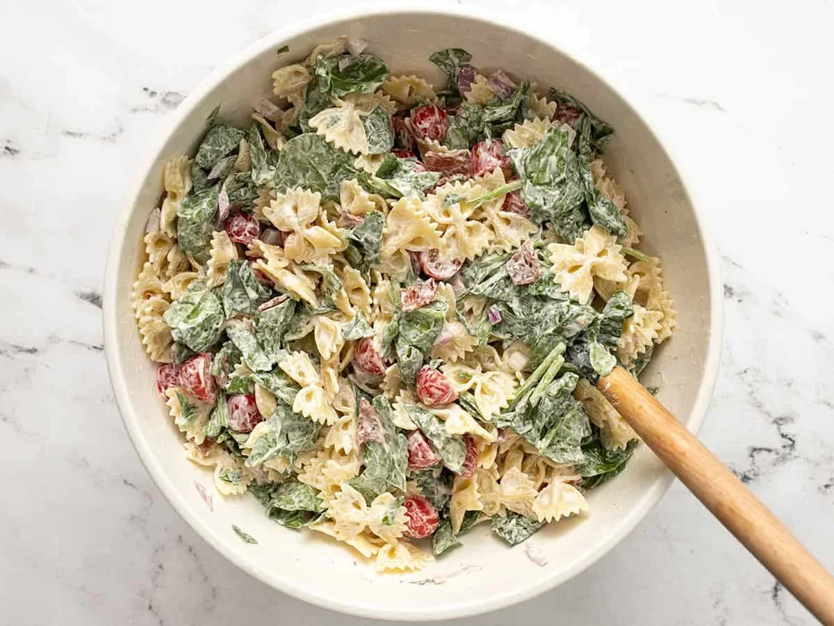 blt pasta salad combines creamy mayo-ranch dressing with crispy bacon, fresh tomatoes, and spinach for the perfect summer side dish. This easy recipe is ideal for BBQs, picnics, and potlucks. Make it now!
