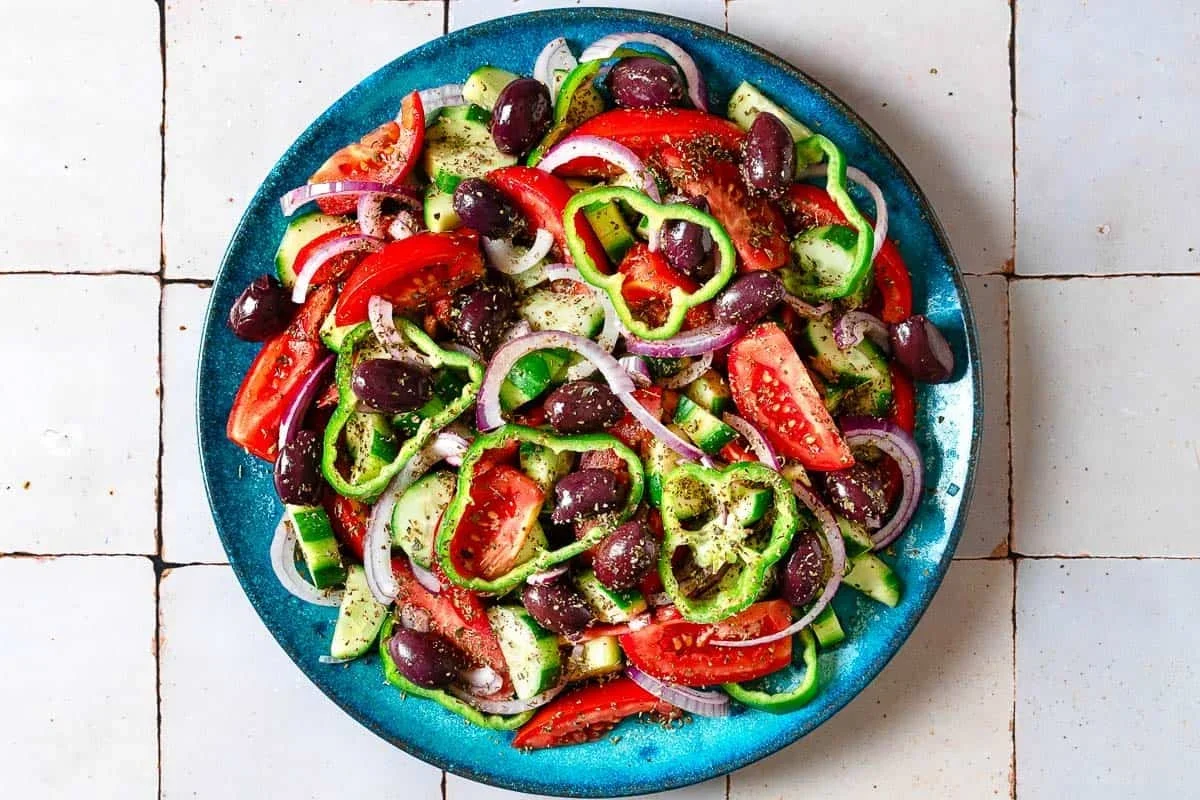 Authentic Greek Salad Recipe That's Easy and Delicious 4 freshly chopped tomatoes, cucumber and peppers for traditional Greek salad