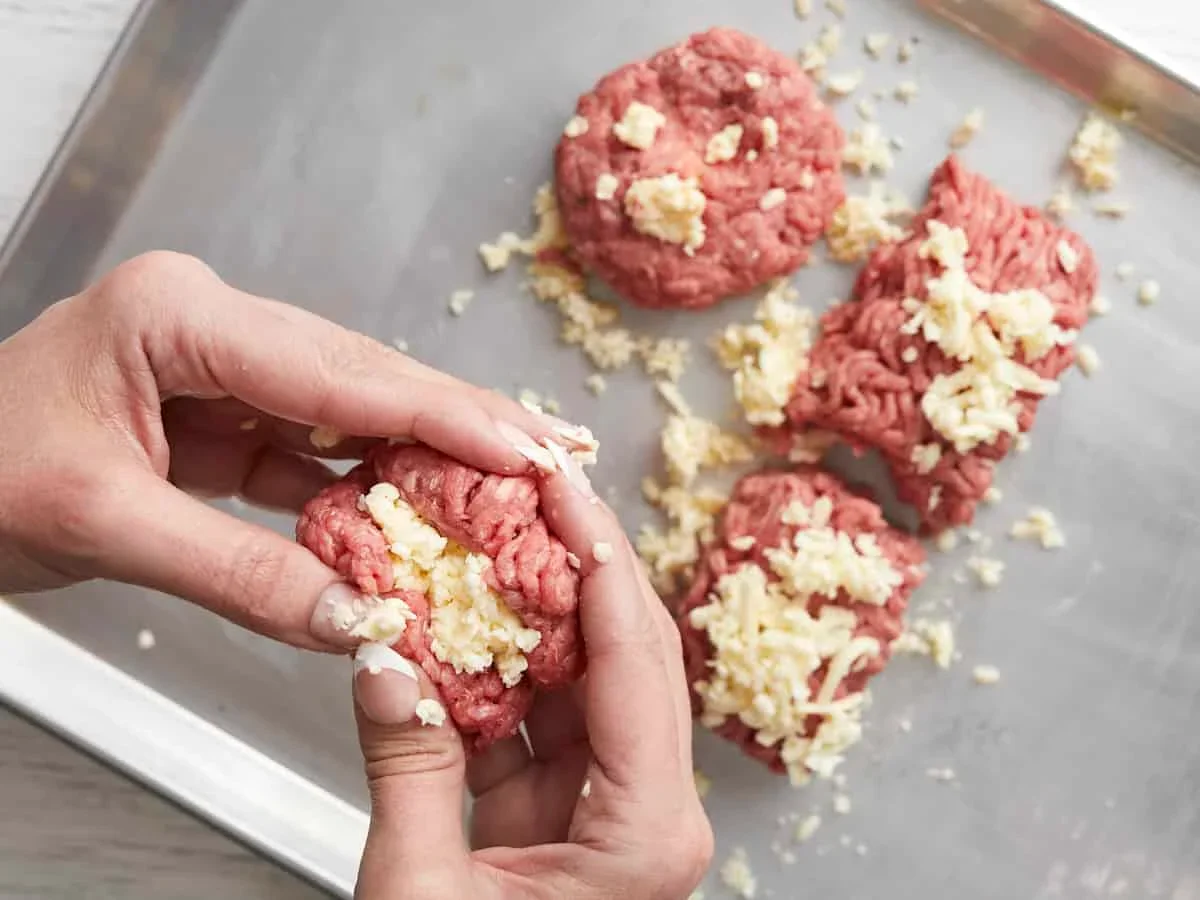 Easy Smash Burger Recipe with Crispy Edges in 30 Minutes 5 grated frozen butter being added to ground beef for juicy burgers
