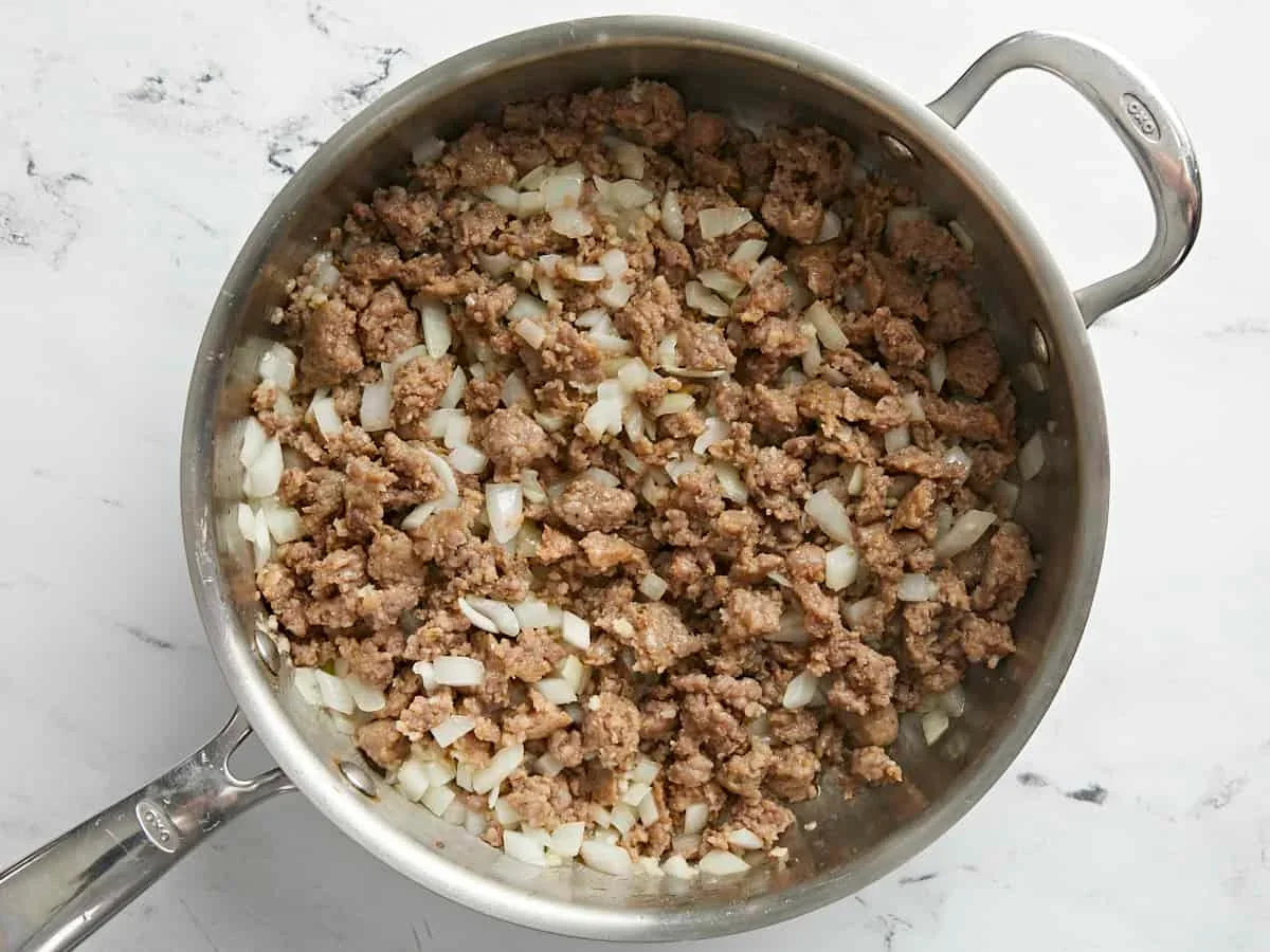 sautéed onion and garlic with Italian sausage in a skillet for stuffed peppers